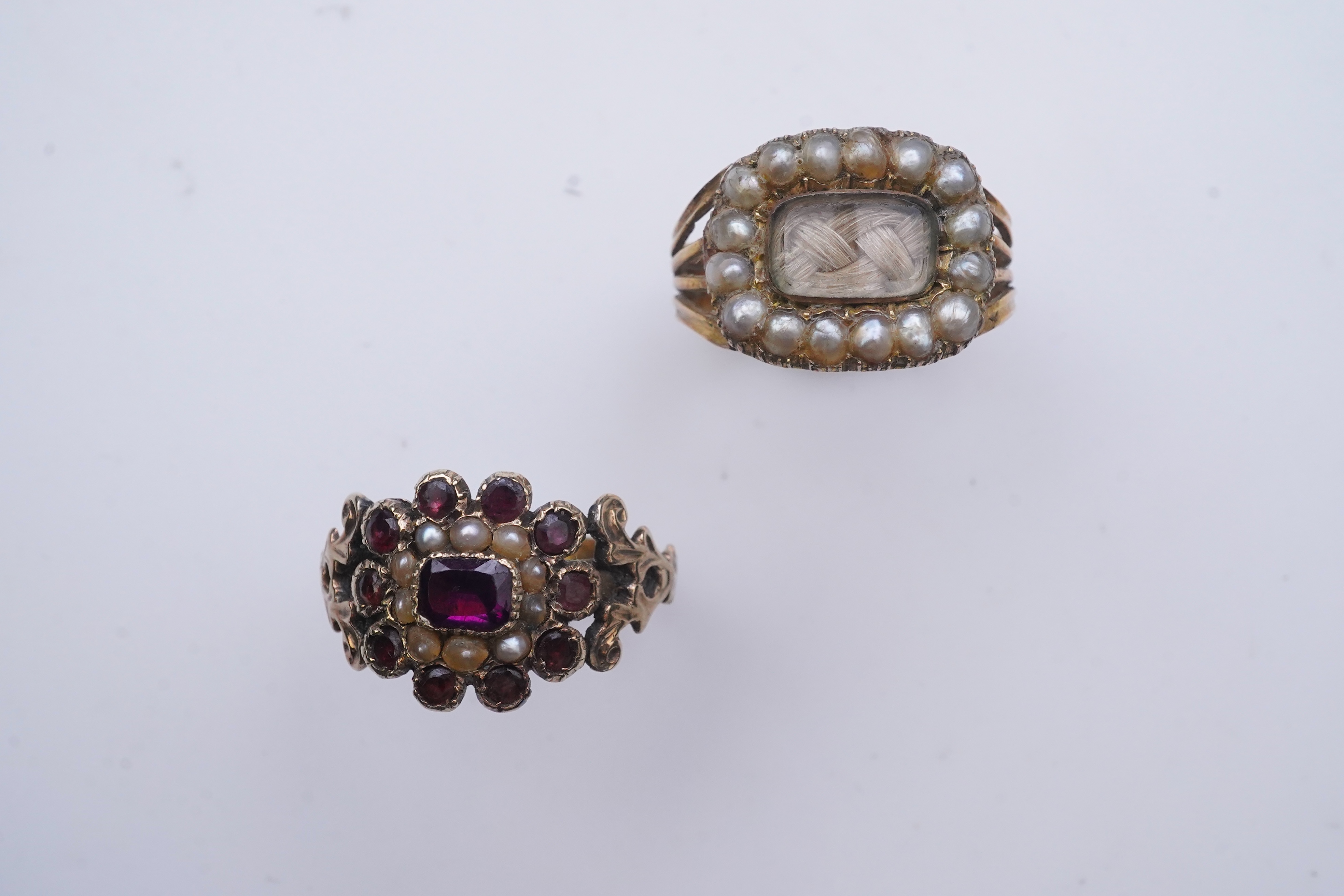 A George III seed pearl mourning ring and a garnet and seed pearl ring, mid 19th century